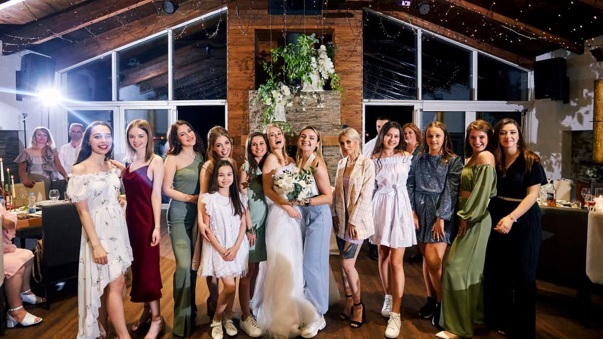 A joyful group portrait of women celebrating at a modern wedding reception.